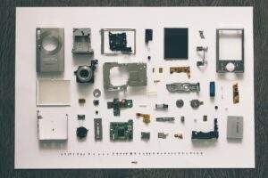 電子產品拆解零件排列圖，展示廢舊電子設備經過精密分類後的各類組件，用於說明在地循環經濟中的電子垃圾資源化處理流程。